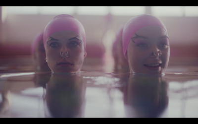 two women in a pool with their heads in the water