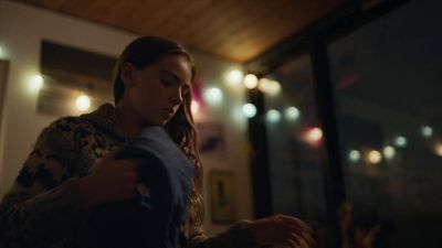 a woman standing in front of a window at night