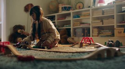 a young girl playing with a toy train set