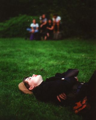 a person laying on the ground in the grass