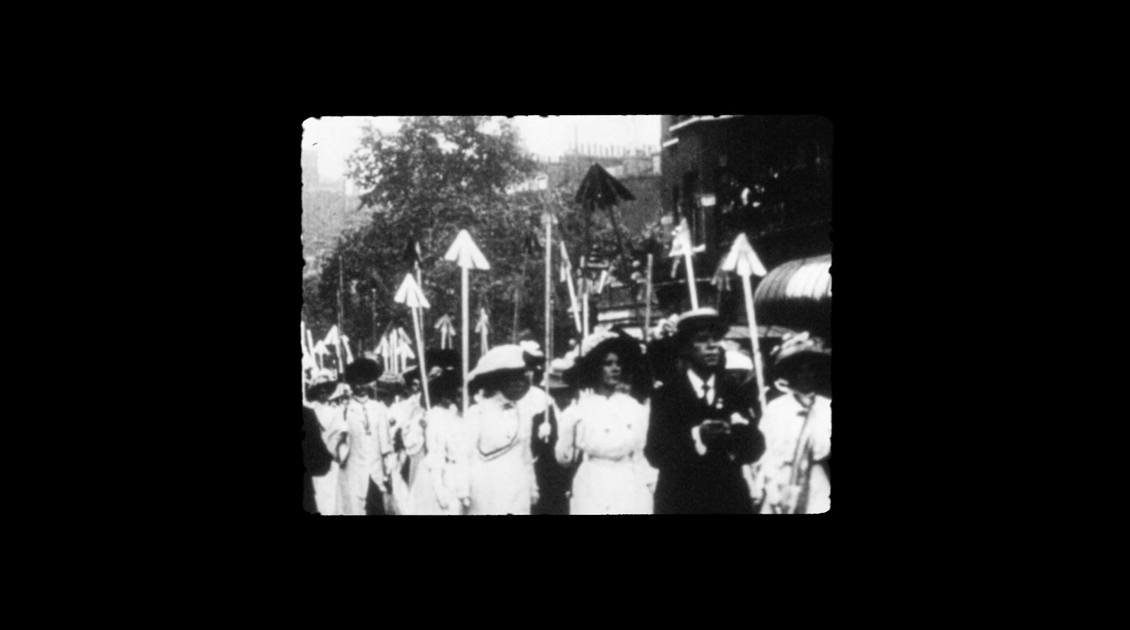 a group of people walking down a street holding flags