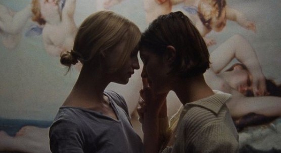 two women standing next to each other in front of a painting