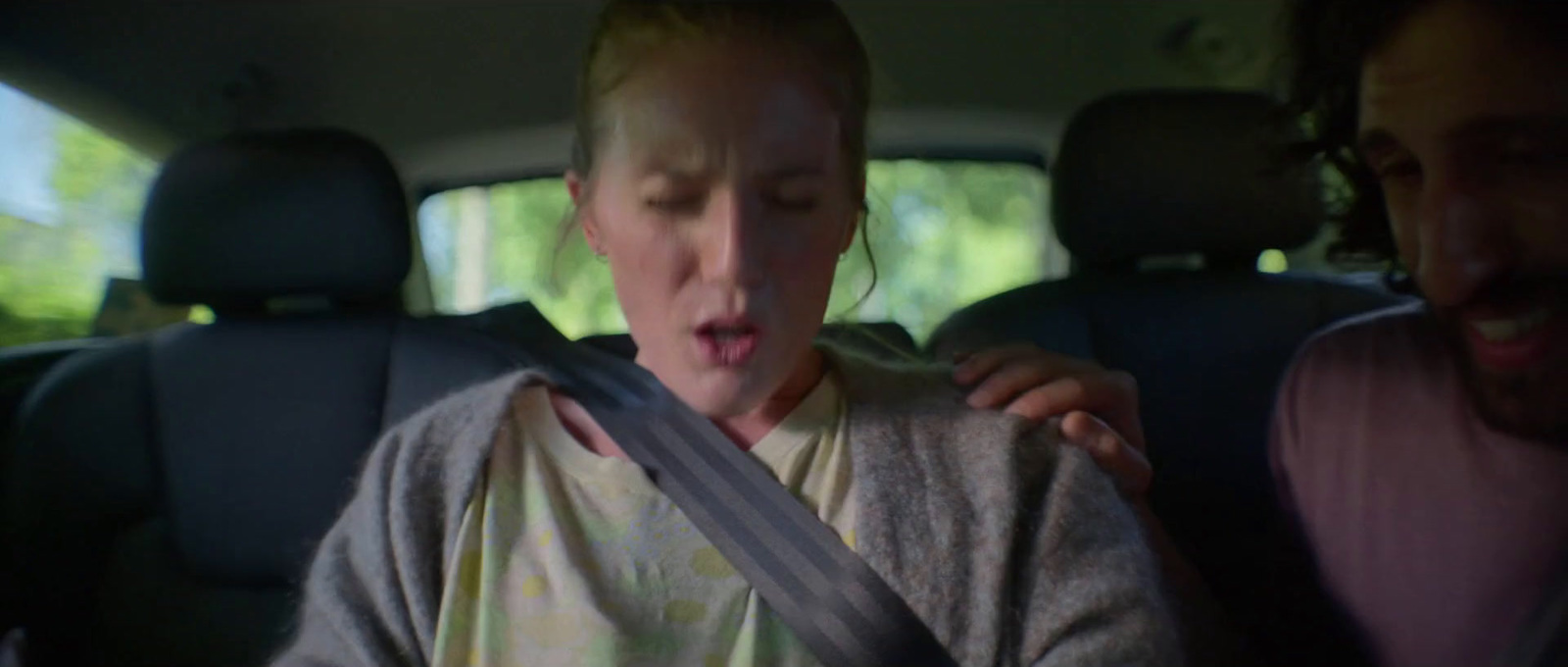 a woman sticking her tongue out in the back seat of a car