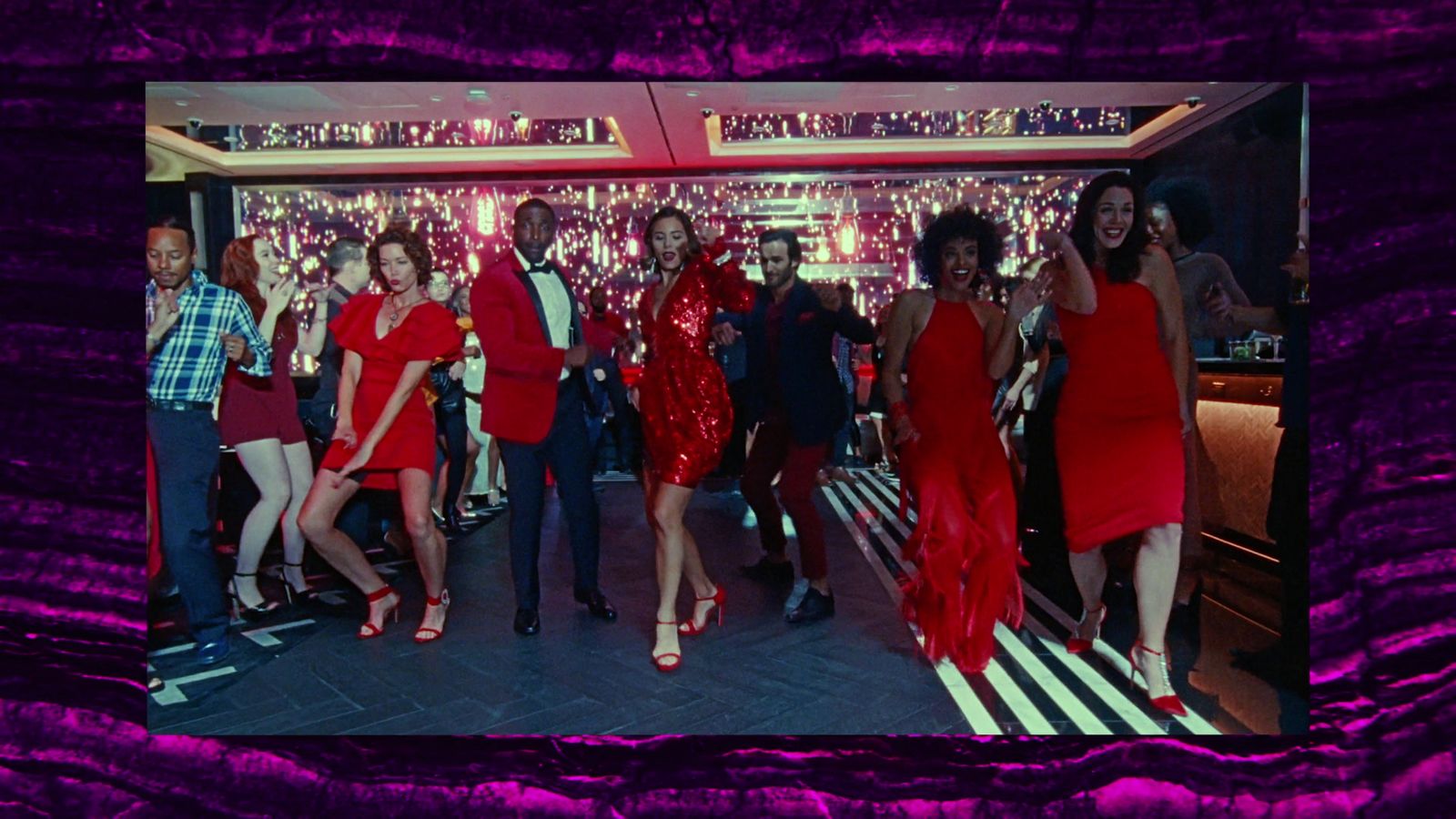 a group of women in red dresses standing in front of a bar