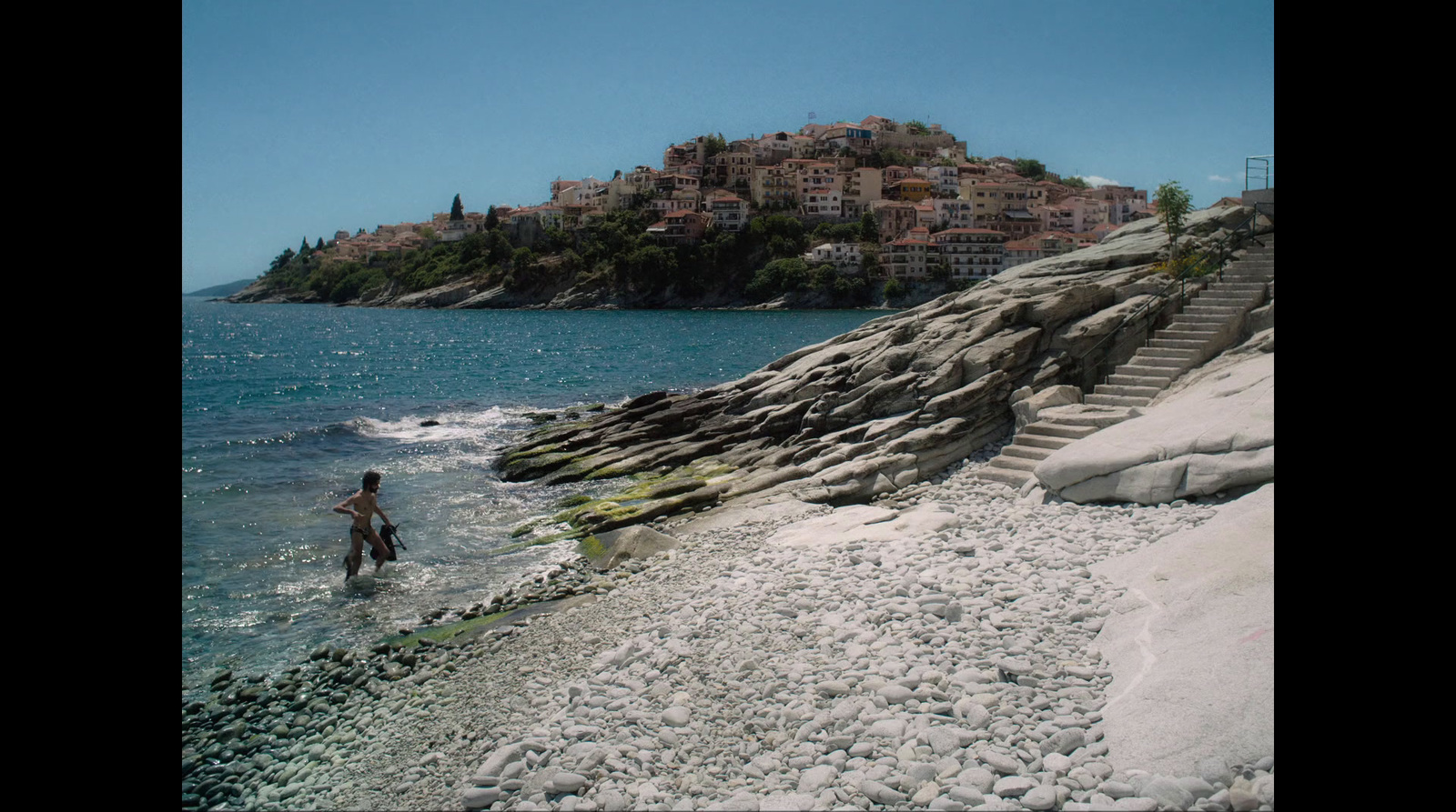 a person walking on a beach next to the ocean