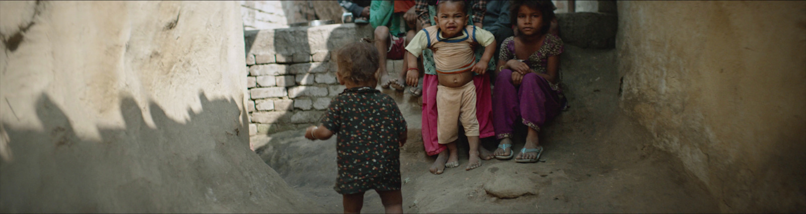 a group of children standing in a narrow alley