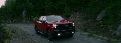 a red truck driving down a dirt road