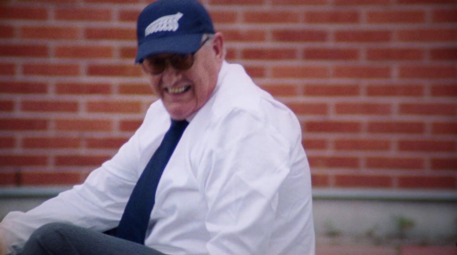 an older man wearing a hat and tie