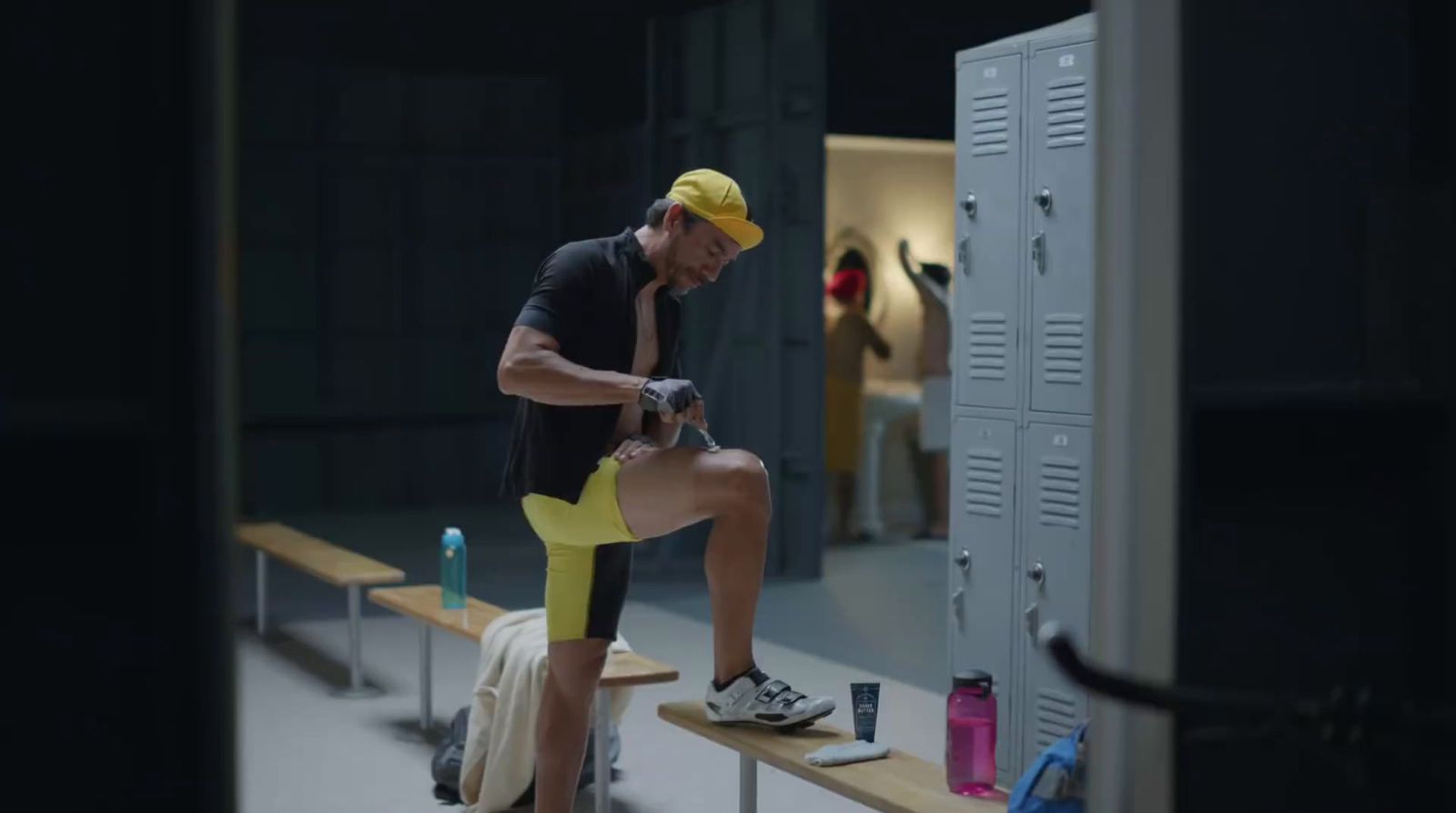 a man sitting on top of a bench next to a locker