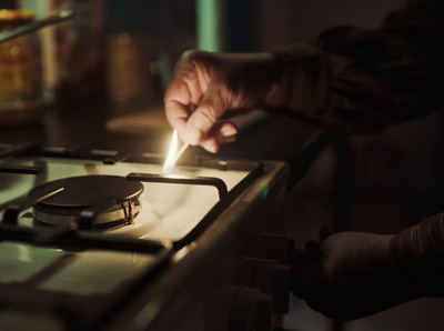 a person lighting a cigarette on top of a stove