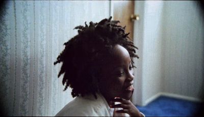 a woman with dreadlocks brushing her teeth