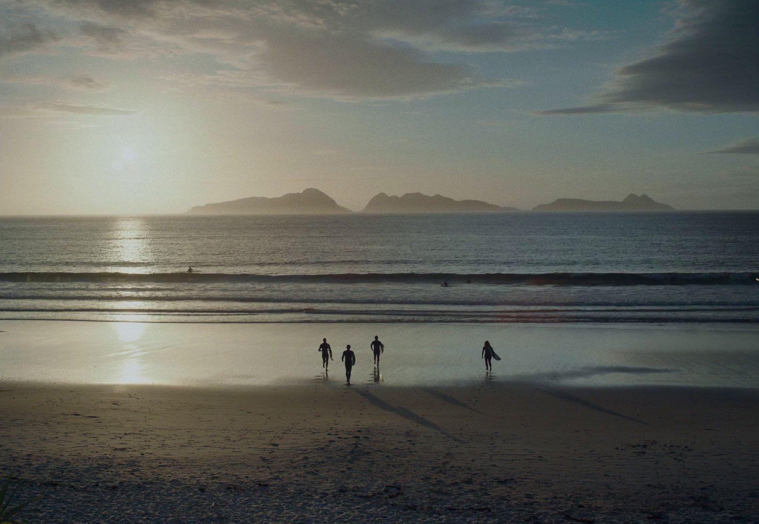 a group of people standing on top of a sandy beach