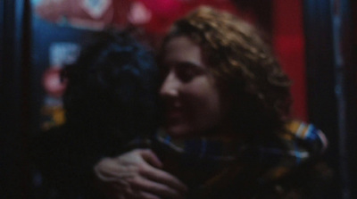 a woman is hugging a man in a dark room