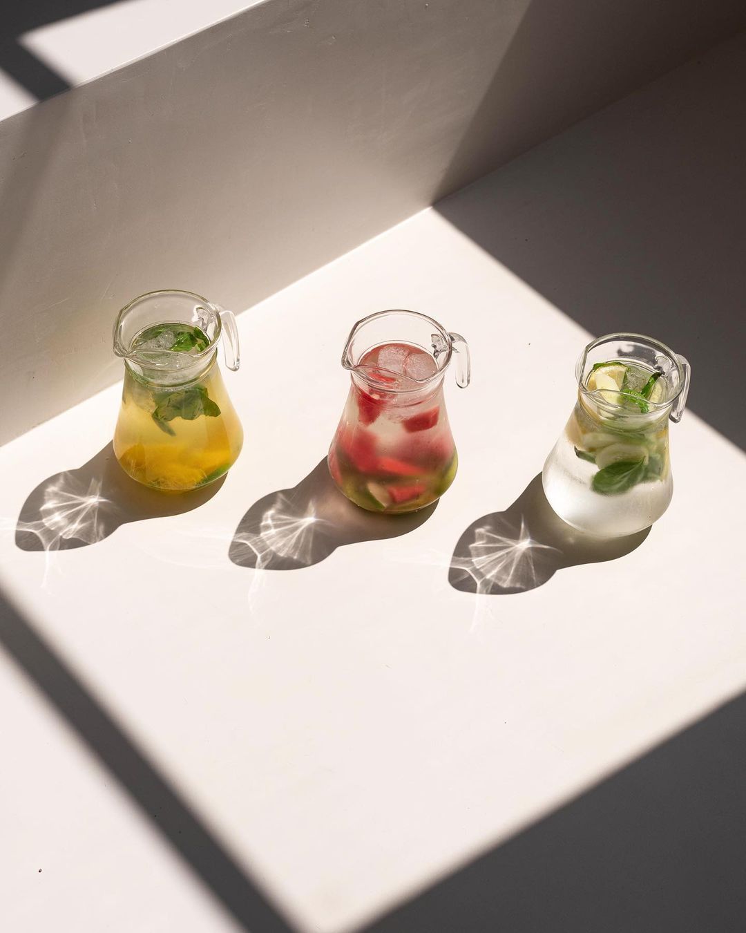 three glasses of drinks are sitting on a table