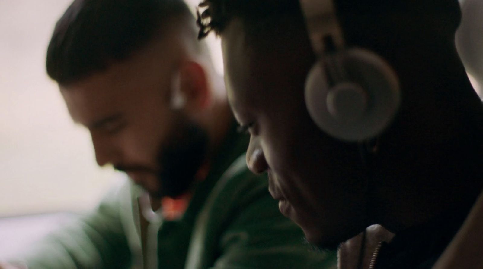 two men sitting next to each other with headphones on