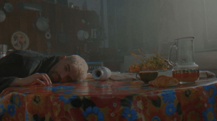 a man laying on a table in a kitchen