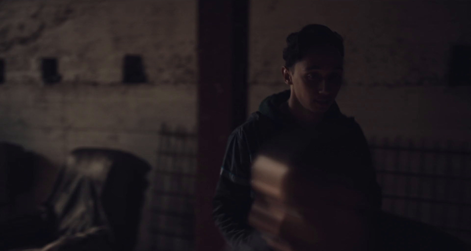 a man standing in a dark room holding a book