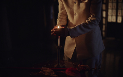 a person holding a lit candle in their hand