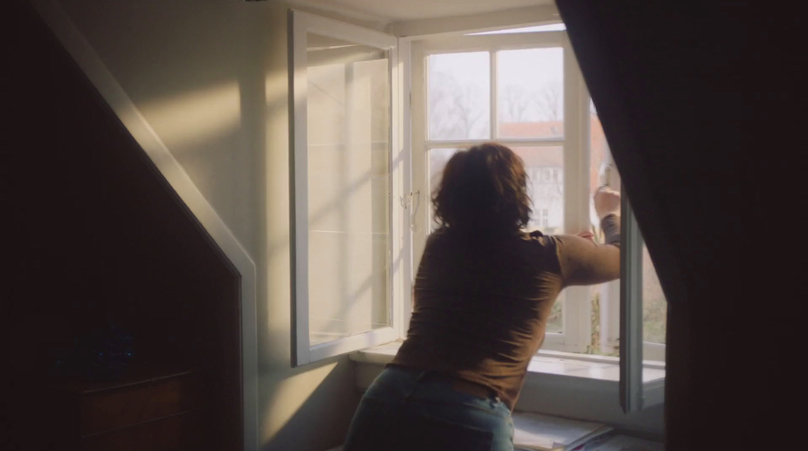 a woman is looking out of a window