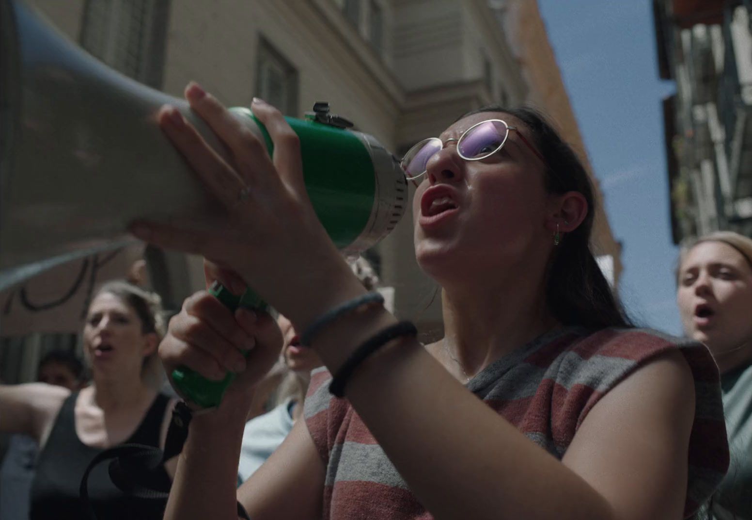 a woman holding a green and white megaphone