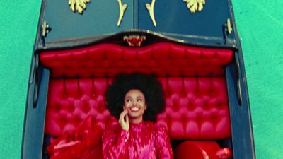 a woman in a red dress sitting in a red couch