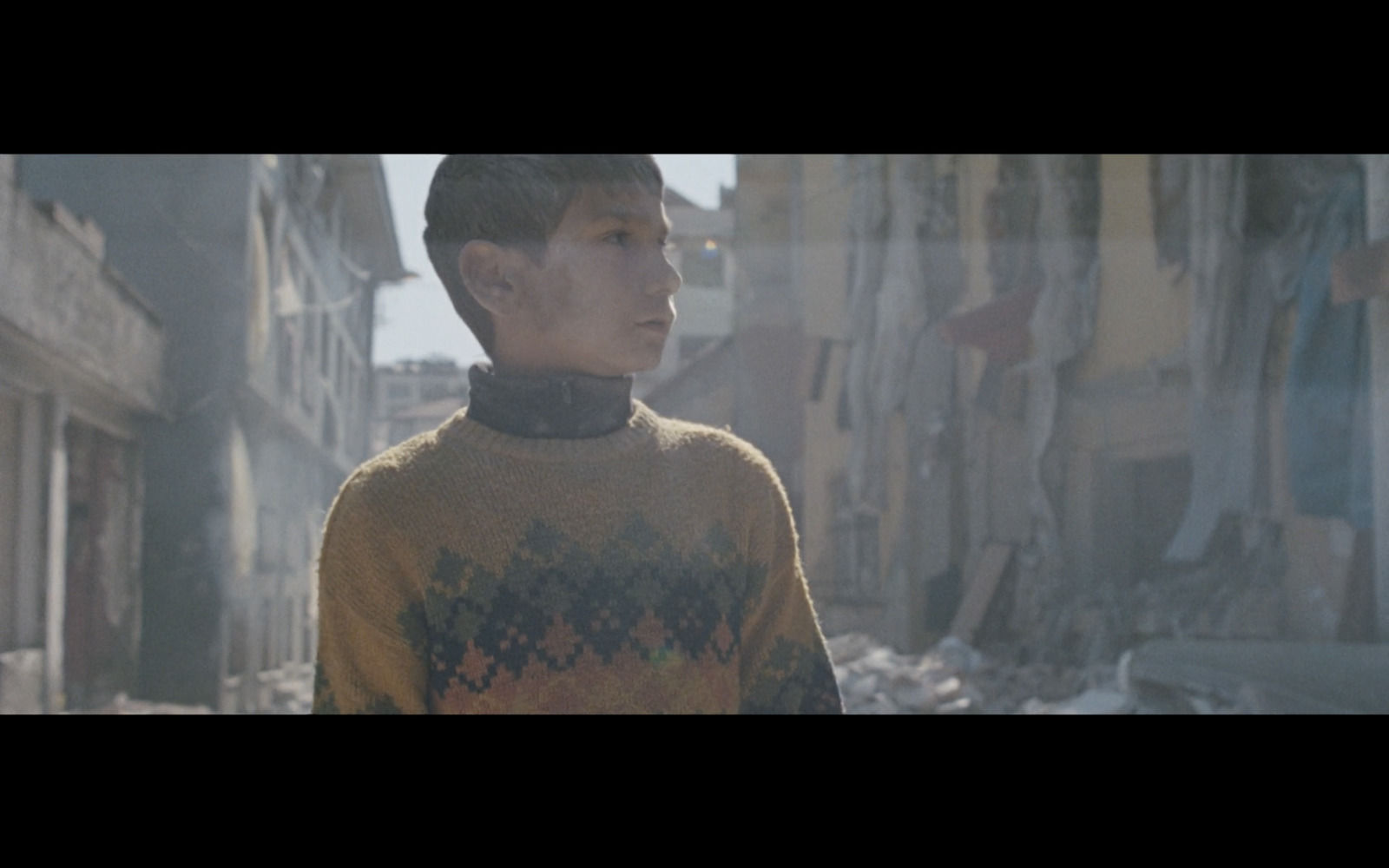 a young man standing in an alley in a city