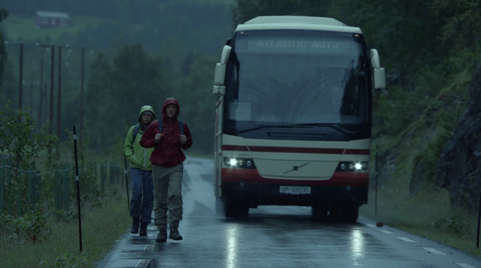 a couple of people standing next to a bus