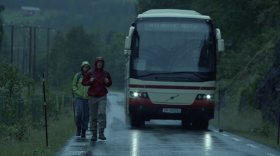 a couple of people standing next to a bus