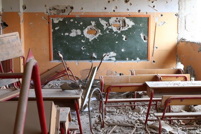 a classroom filled with wooden desks and a chalkboard