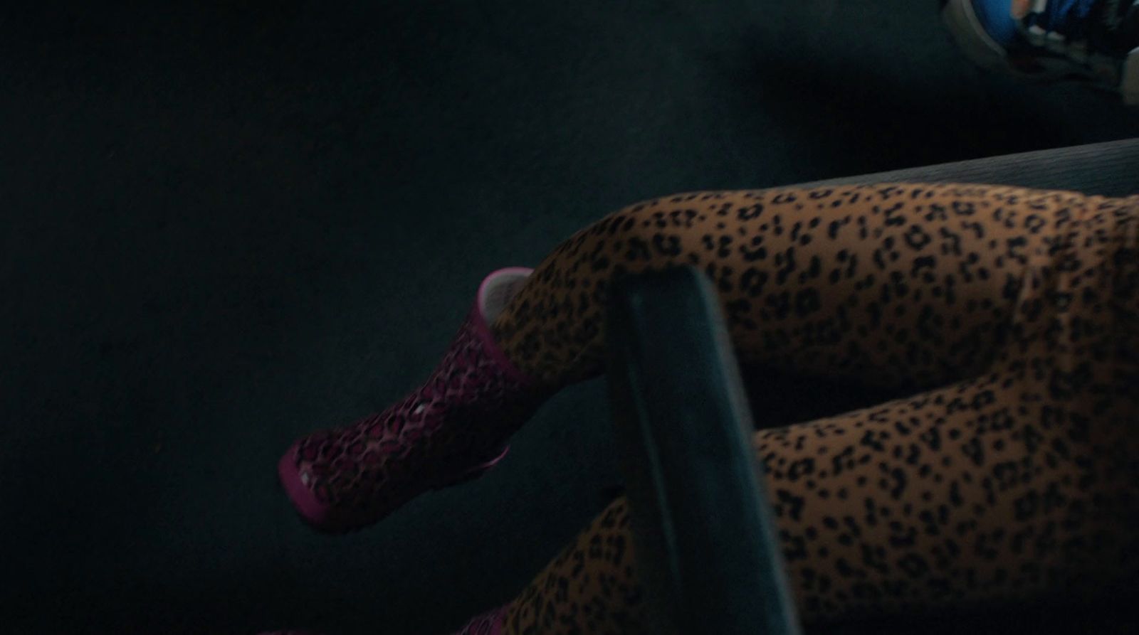 a woman sitting on a bus seat wearing leopard print tights