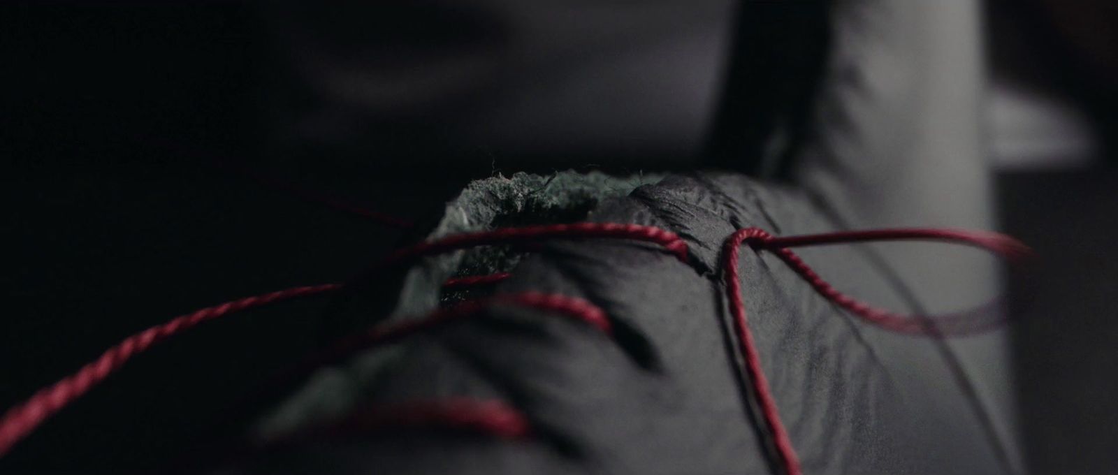 a close up of a red string on a black couch