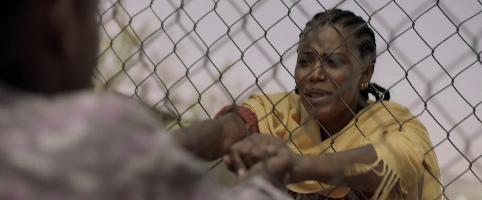 a woman holding a baseball bat behind a fence