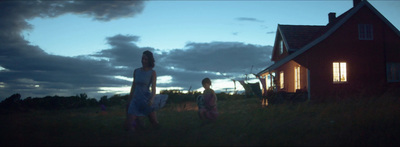 a woman and a child standing in front of a house