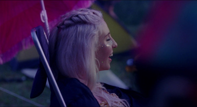 a woman with blonde hair holding a pink umbrella