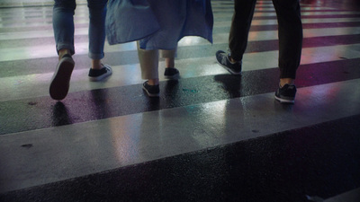 a group of people walking across a cross walk