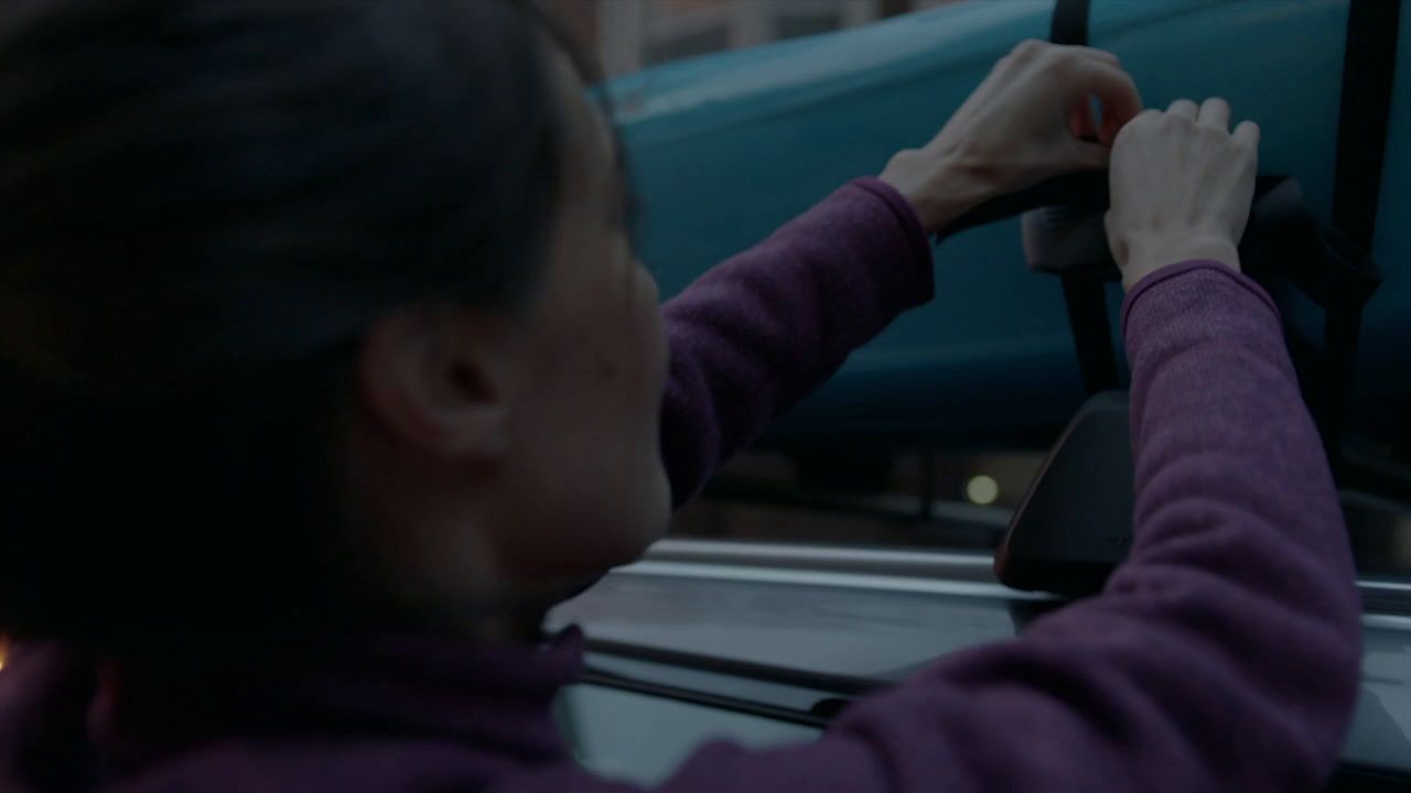 a woman driving a car with her hand on the steering wheel