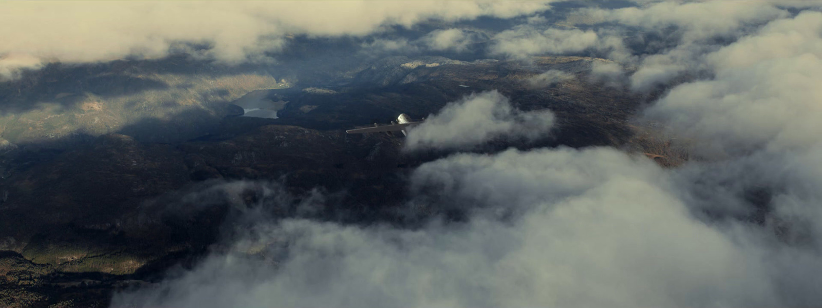 an aerial view of a mountain range covered in clouds