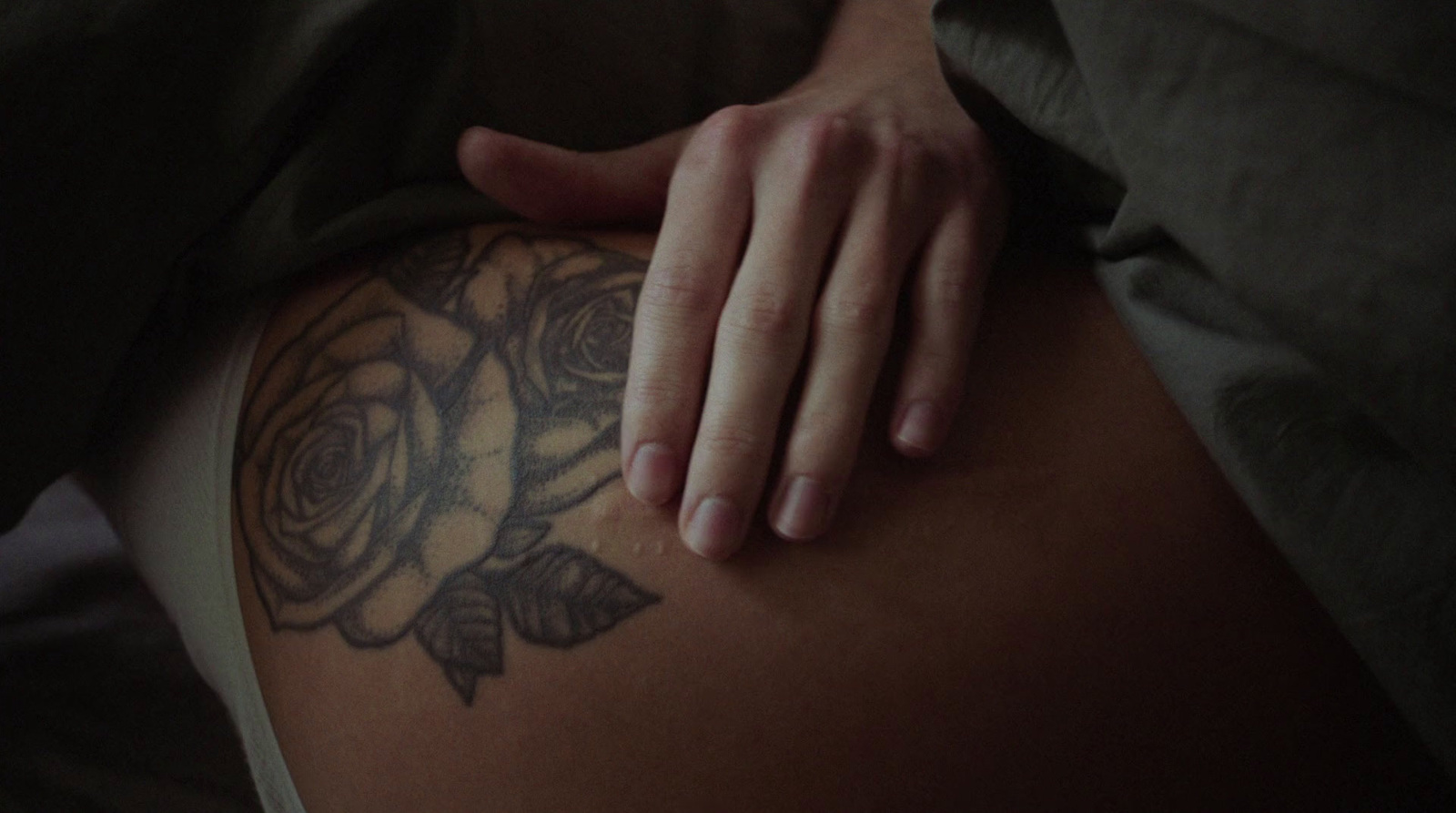 a close up of a person's stomach with a rose tattoo on it