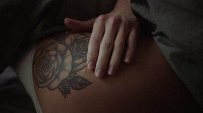 a close up of a person's stomach with a rose tattoo on it