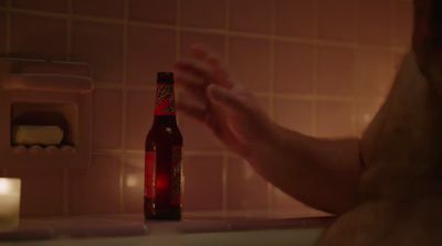 a bottle of beer sitting on top of a bath tub