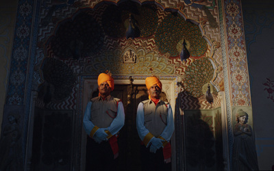 a couple of men standing next to each other in front of a doorway