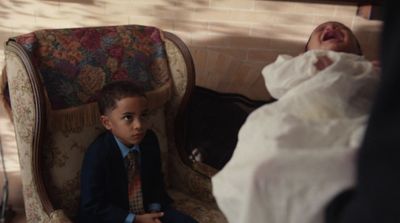 a young boy sitting in a chair next to a woman