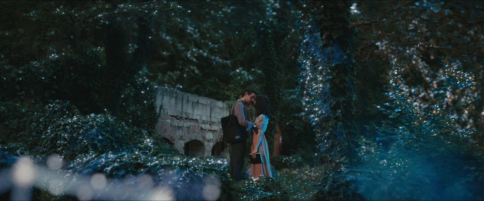 a man and a woman kissing in the woods