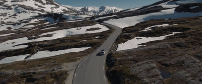 an aerial view of a car driving down a mountain road