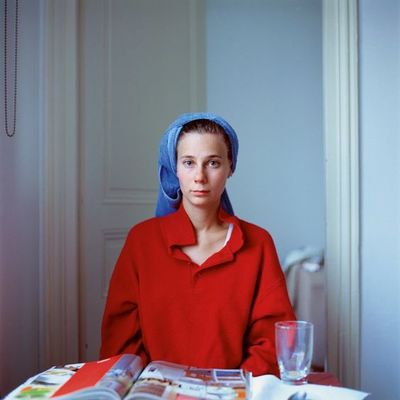 a woman sitting at a table with a book and a glass