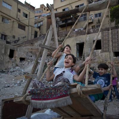 a group of children playing on a wooden swing