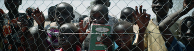 a group of people behind a chain link fence