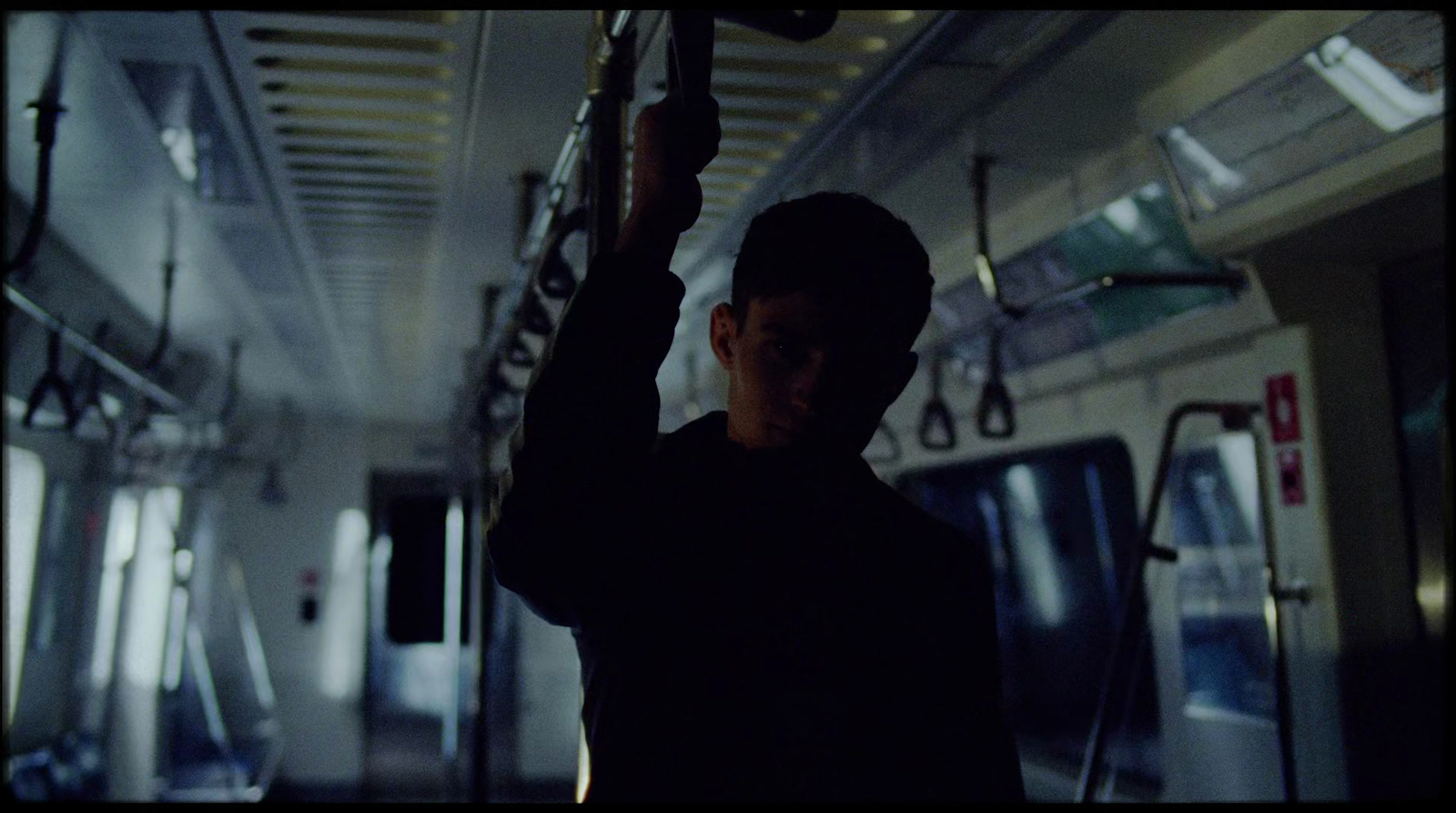 a young man is standing in a train car