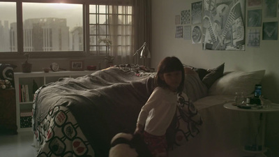 a little girl standing on a bed in a room