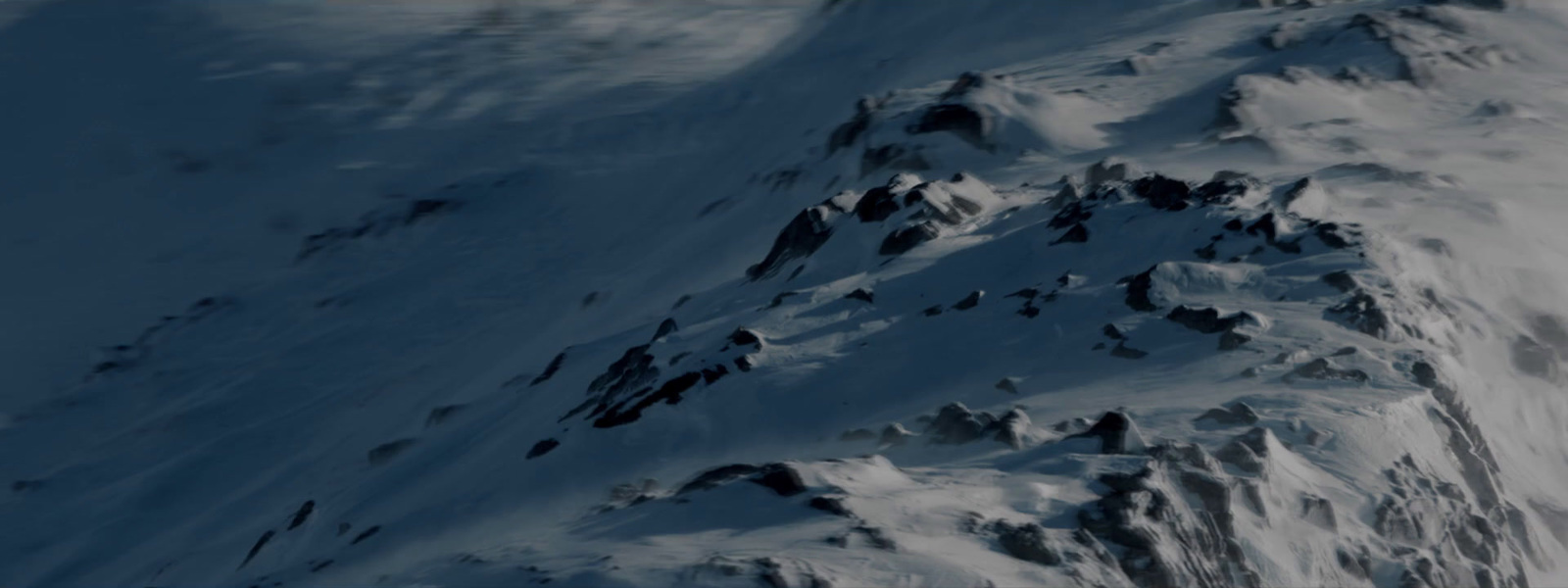 a snowboarder is going down a snowy mountain